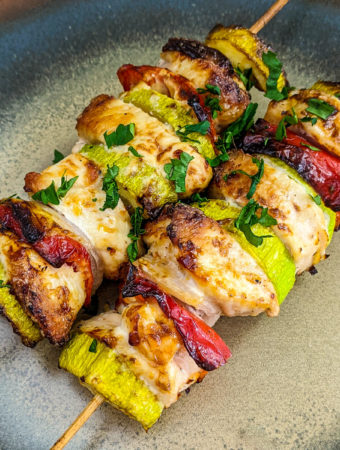Close look of chicken skewers on a plate.