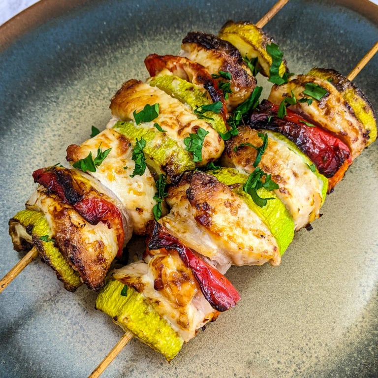 Close look of chicken skewers on a plate.