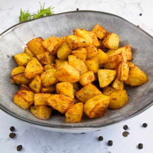 Close look of diced potatoes with paprika cooked in air fryer.