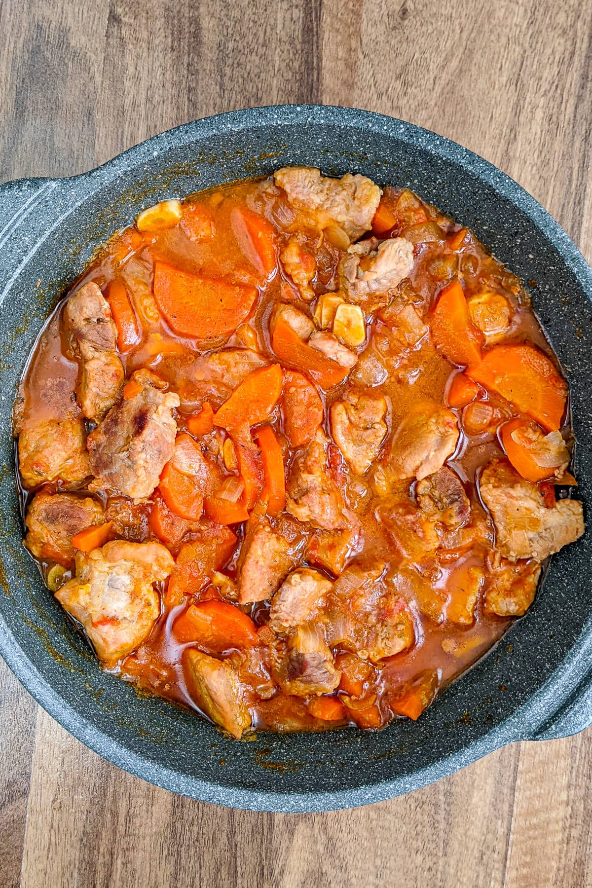 Top view of a sauce pan with pork stew.