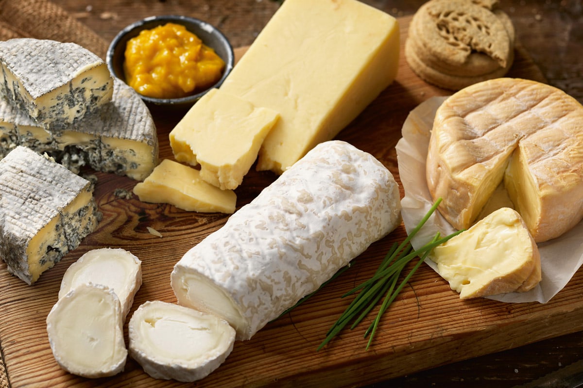Different types of goat cheeses on wooden.