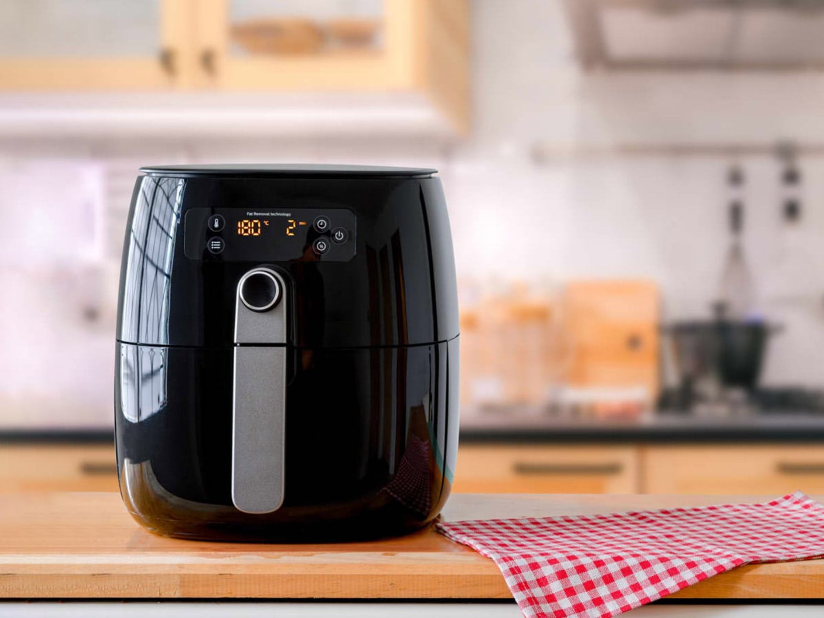 Digital air fryer on a wooden table.