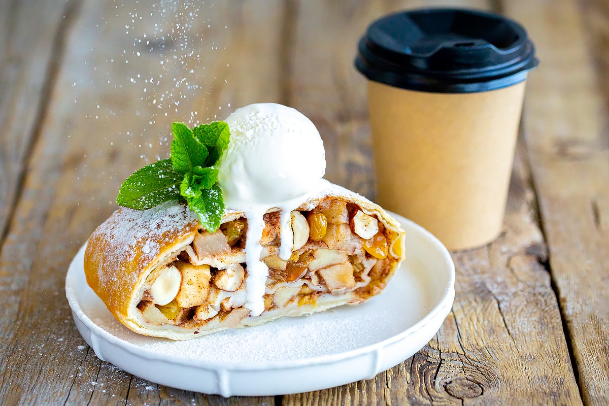Delicious apple strudel with ice cream and coffee cup.