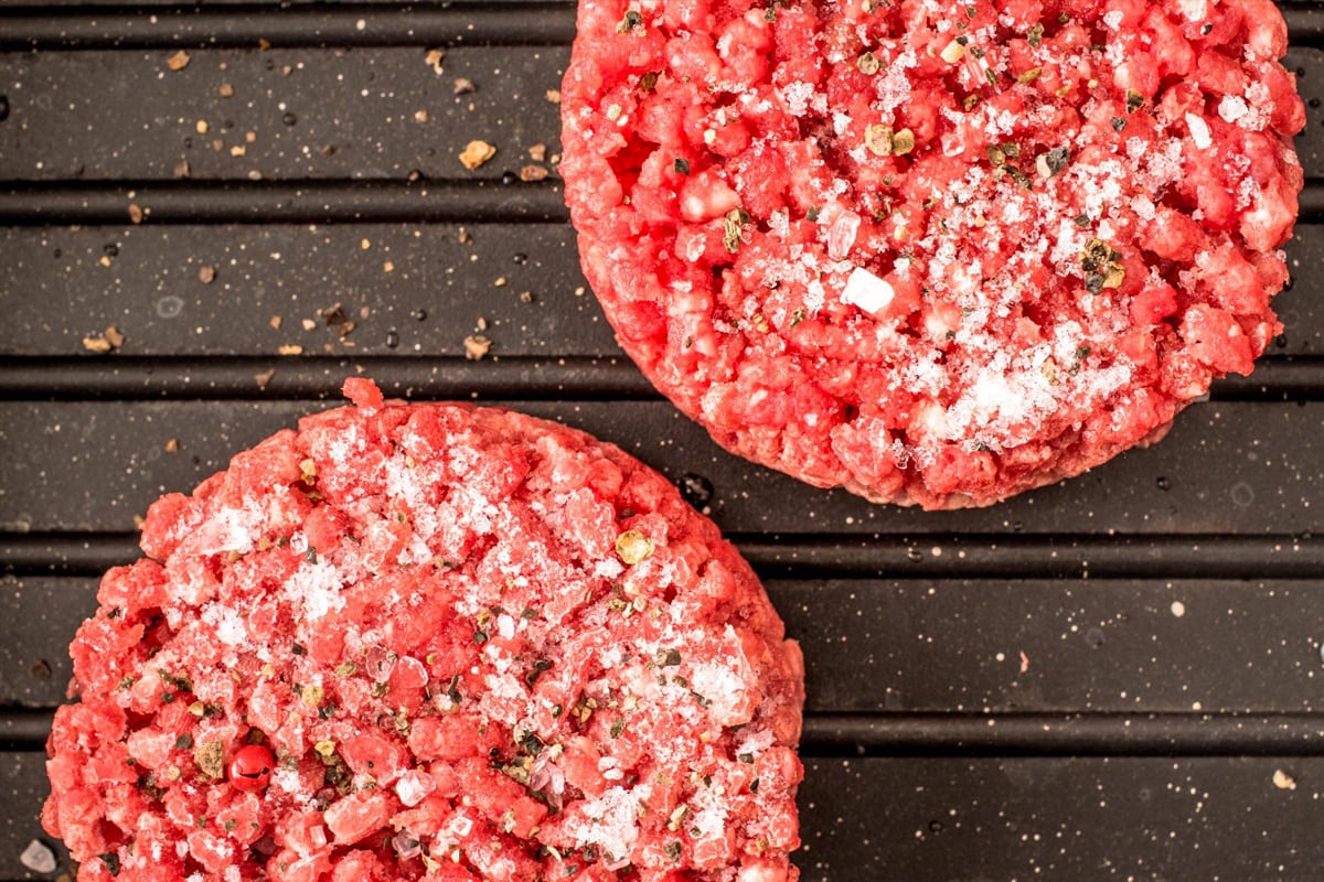 Top view of two frozen burger mince on a pan.