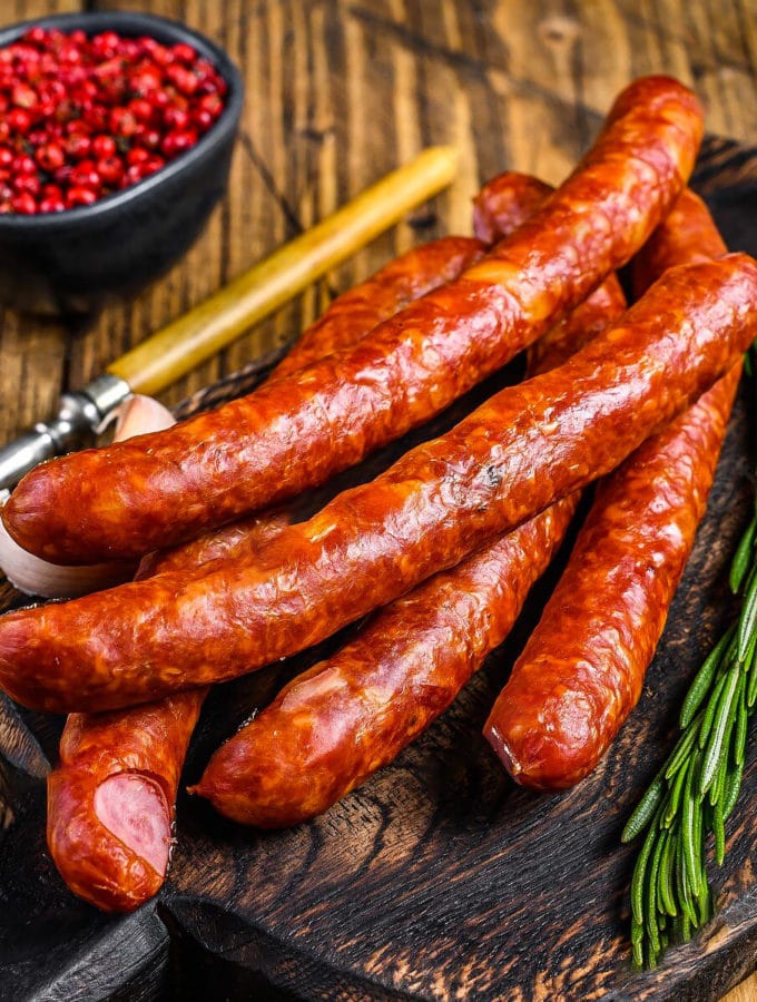 Top view of smoked sausages with ketchup and rosemary.