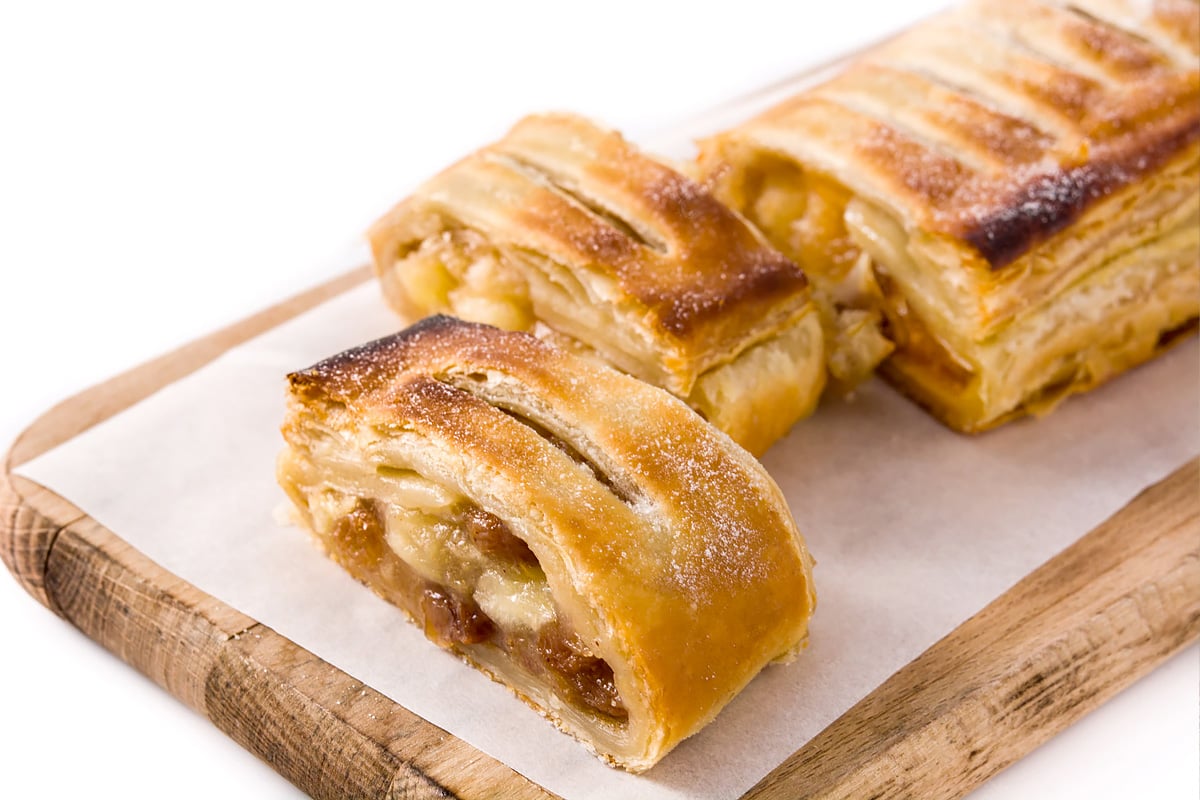 Slices of apple strudel on wooden cutting board.