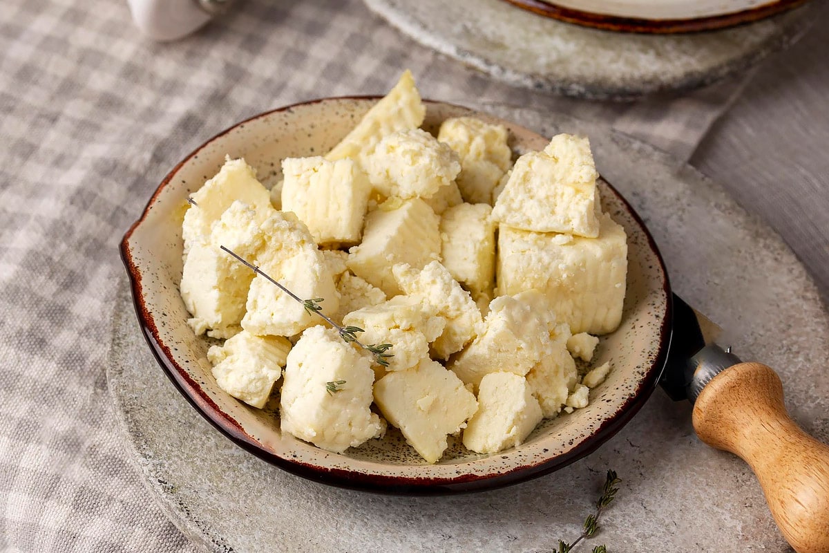 Rustic background with paneer cheese cubes.
