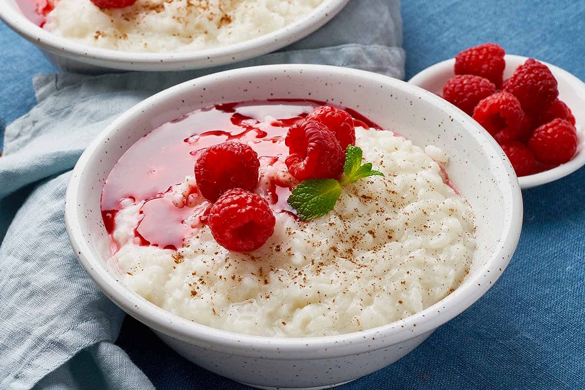 Reheated rice pudding with raspberry and mint leaf.