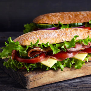 Close look of a sandwich with lettuce, tomatoes, bacon and cheese.