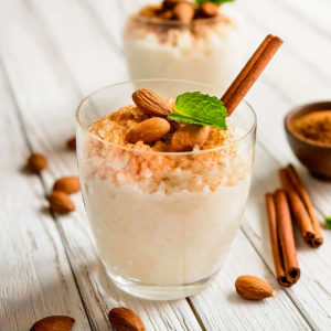 Glass with rice pudding with cinnamon and almonds.