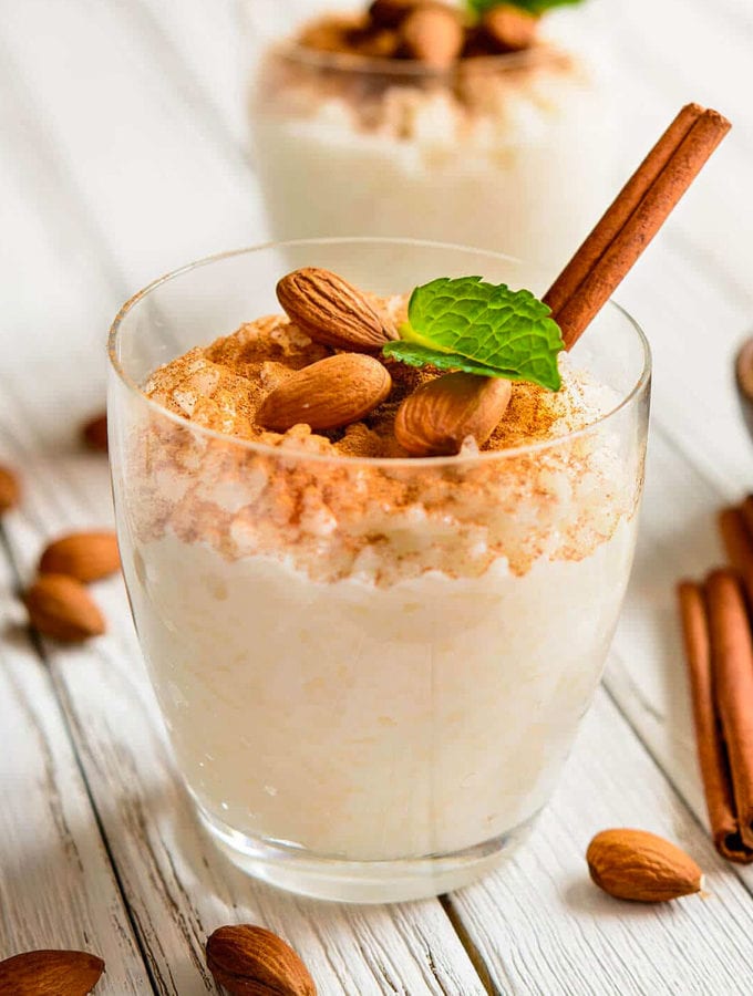 Glass with rice pudding with cinnamon and almonds.