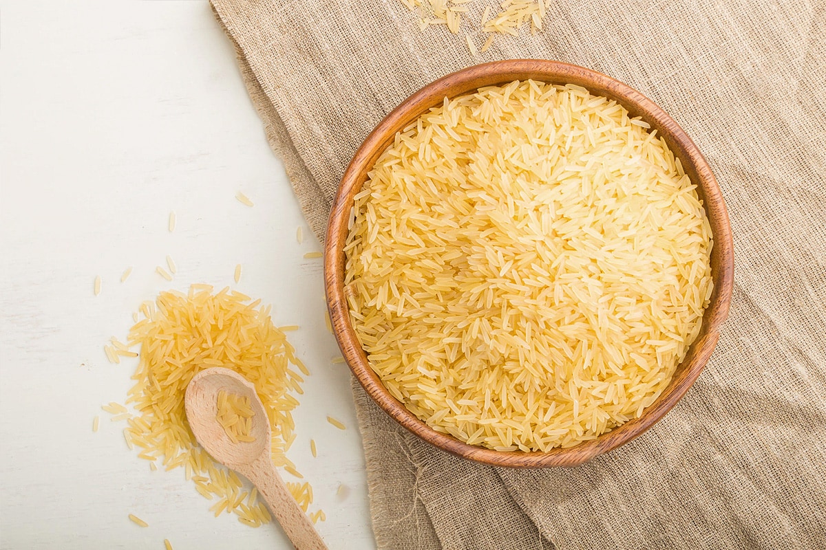 Top view of a wooden plate with yellow rice in a wooden plate.