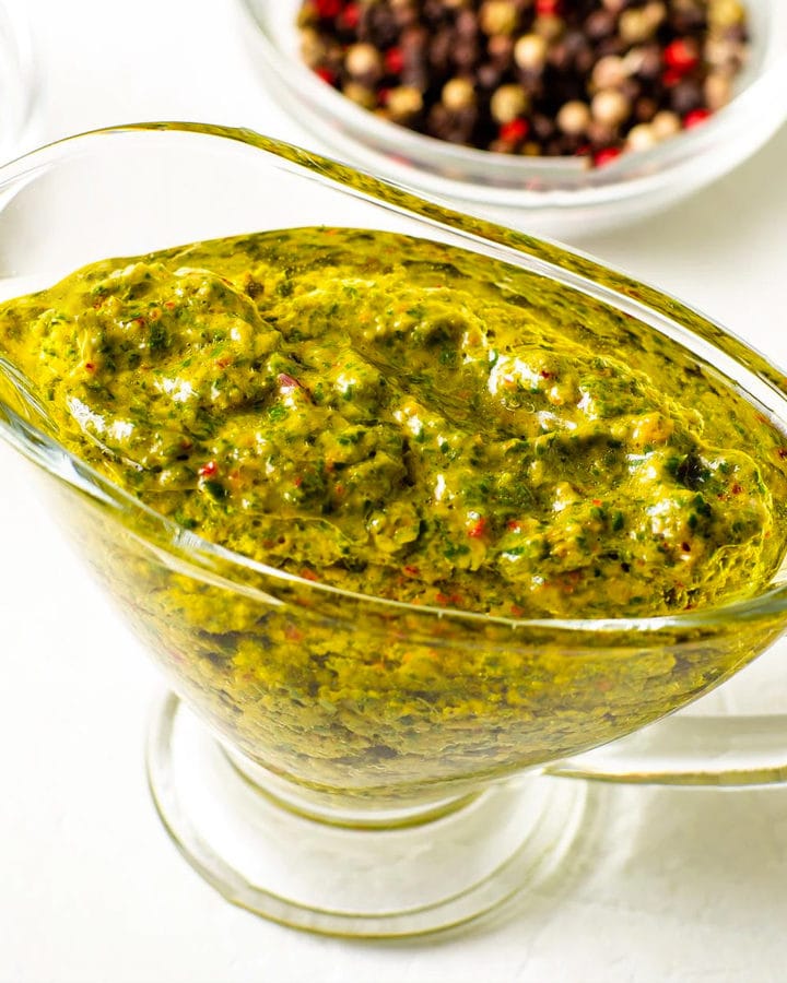 Close look of chimichuri sauce in a glass sauce cup.