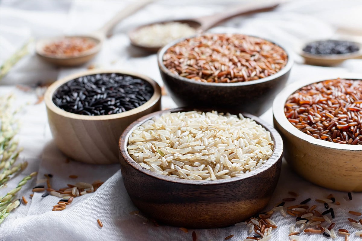Different types of dried rice on wooden plates.