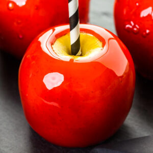 Close look of an apple coated in red caramel.