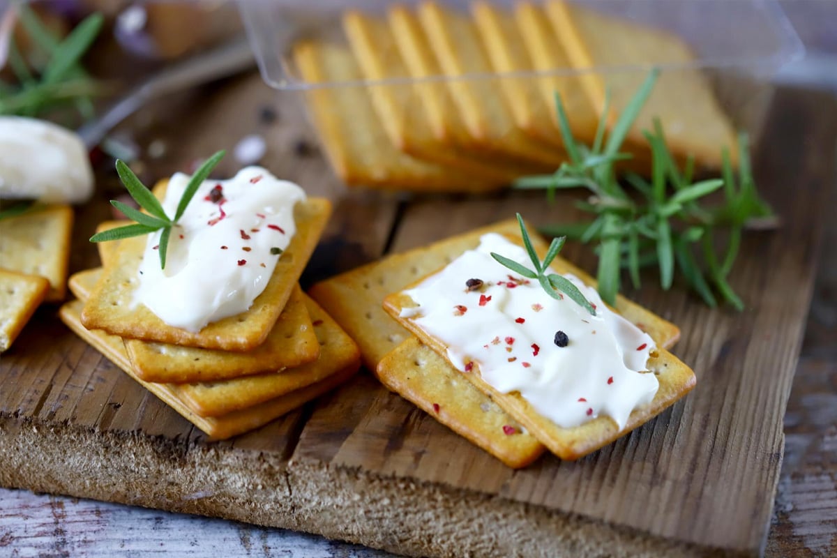 Crackers with cream, rosemary, and chili flakes.