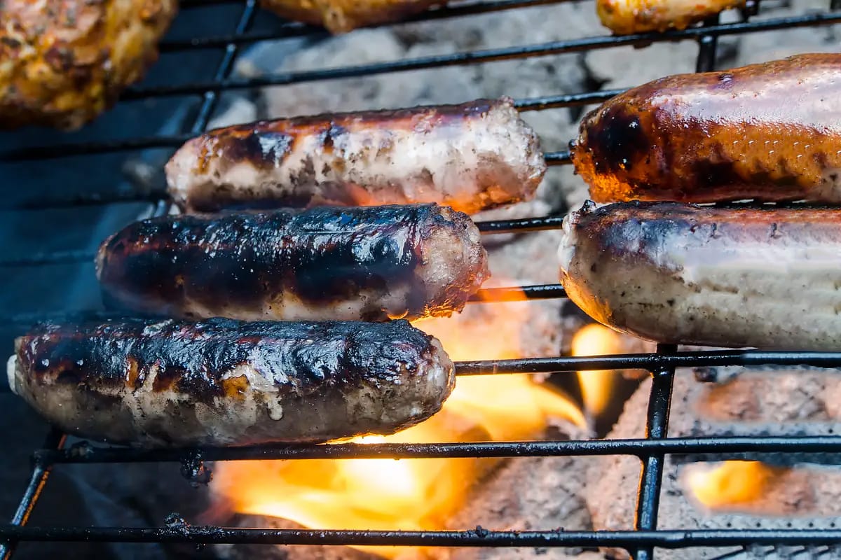 Burnt sausages on a grill rack.