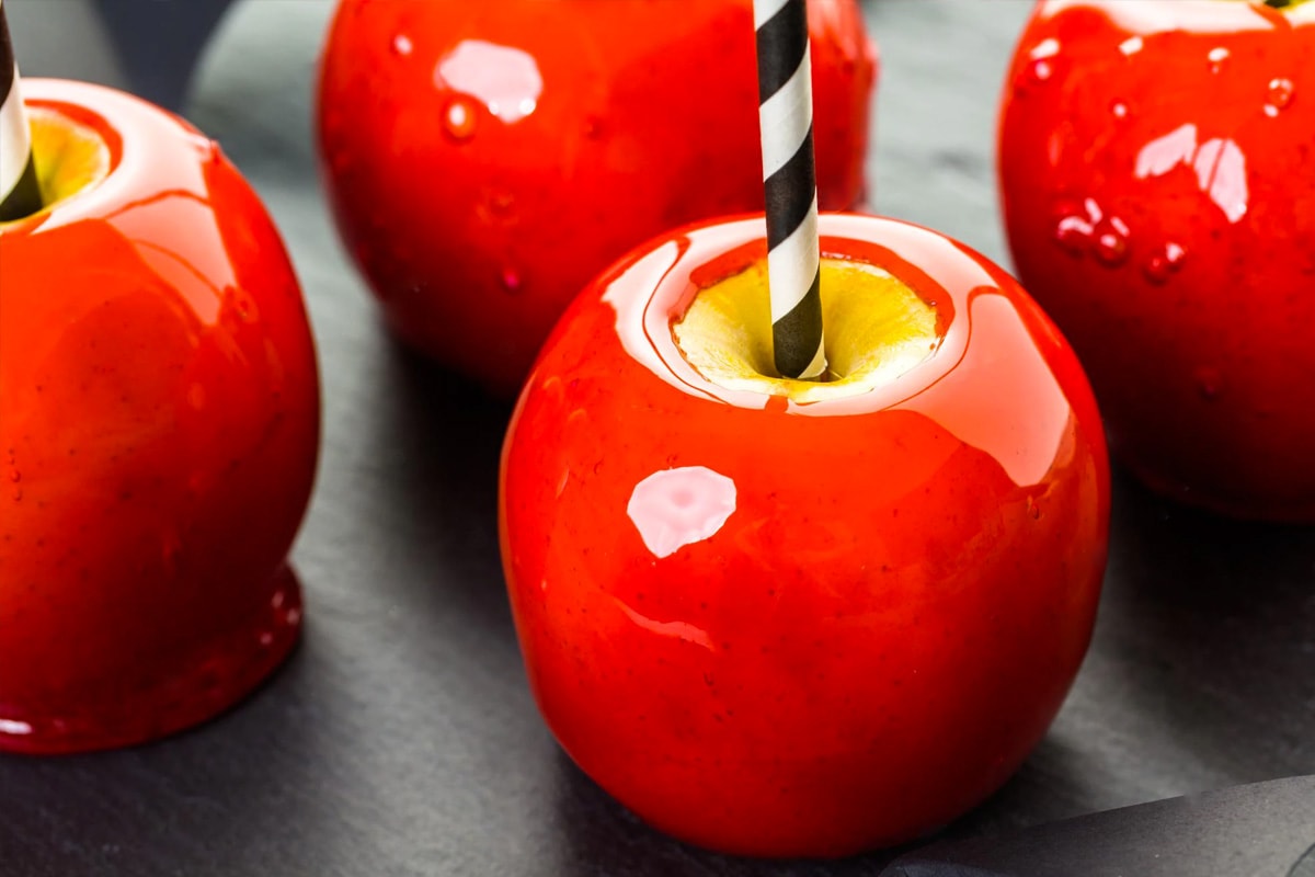 Close look of red candy apples with sticks.