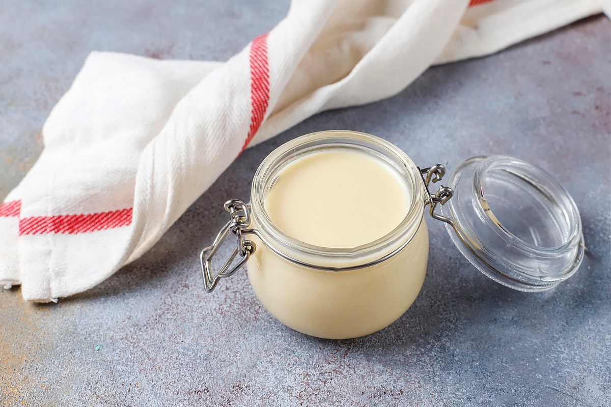 Close look of a glass jar full with condensed milk.