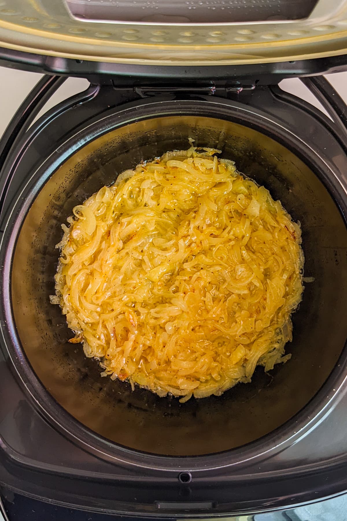 Top view of a slow cooker with caramelized onions.