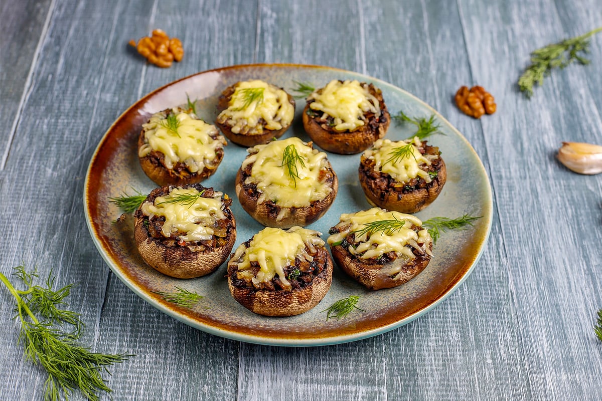Top view of a plate with stuffed mushrooms with melted cheese.