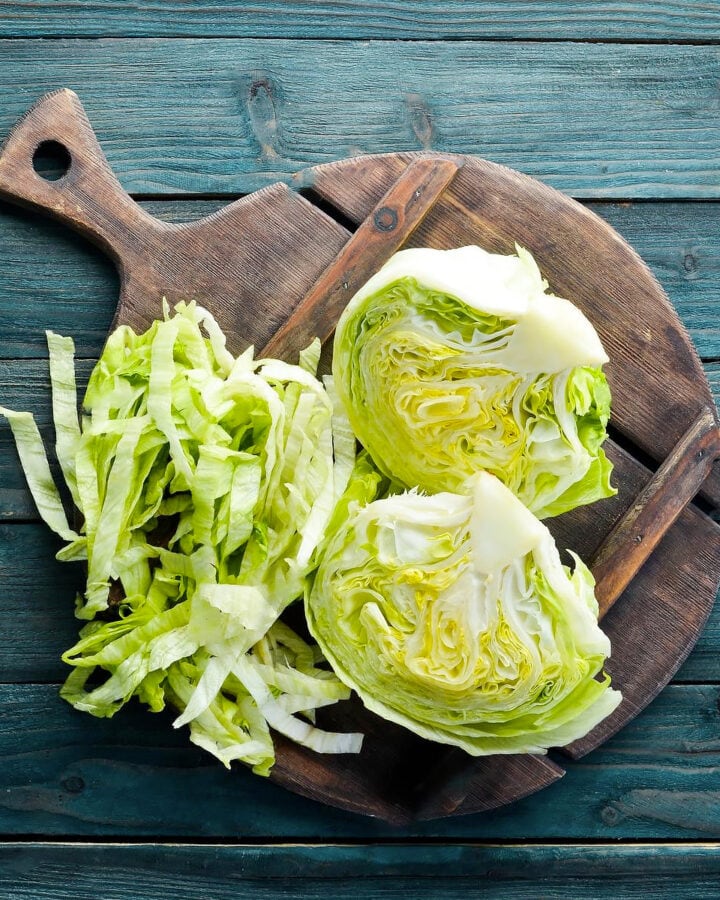 Top view of a chopped lettuce iceberg on a wooden board.