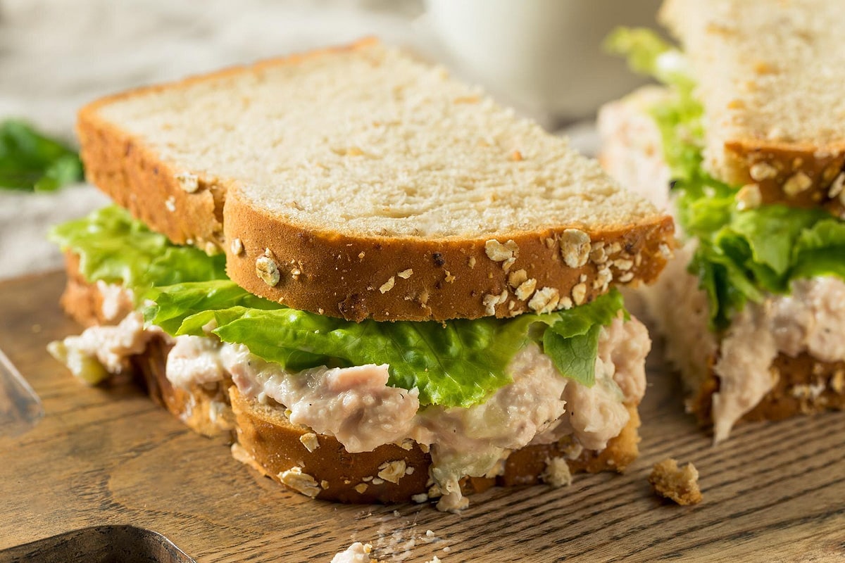 Close view of ham salad sandwiches with salad leaves.