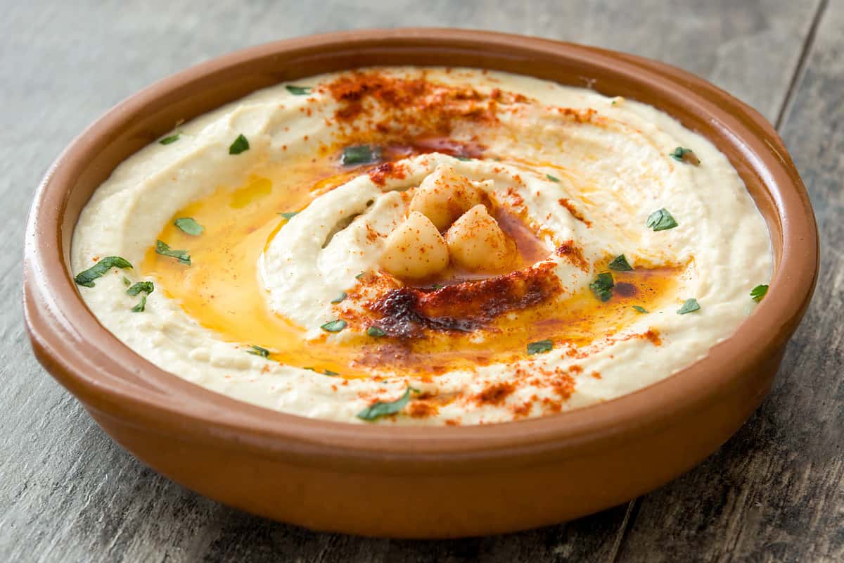 Close view of chickpea hummus with parsley and olive oil.