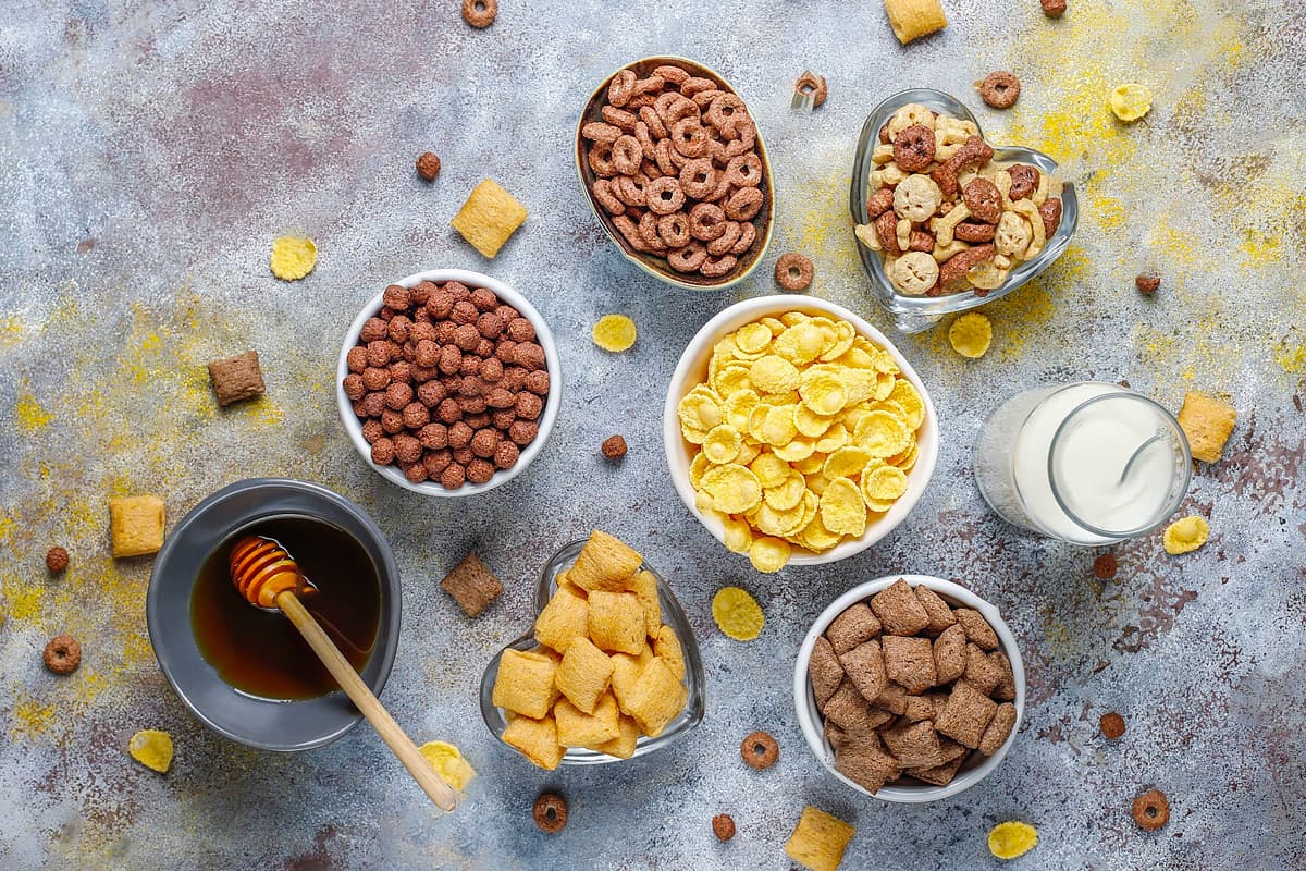 Top view of honey, milk and six types of different cereals.