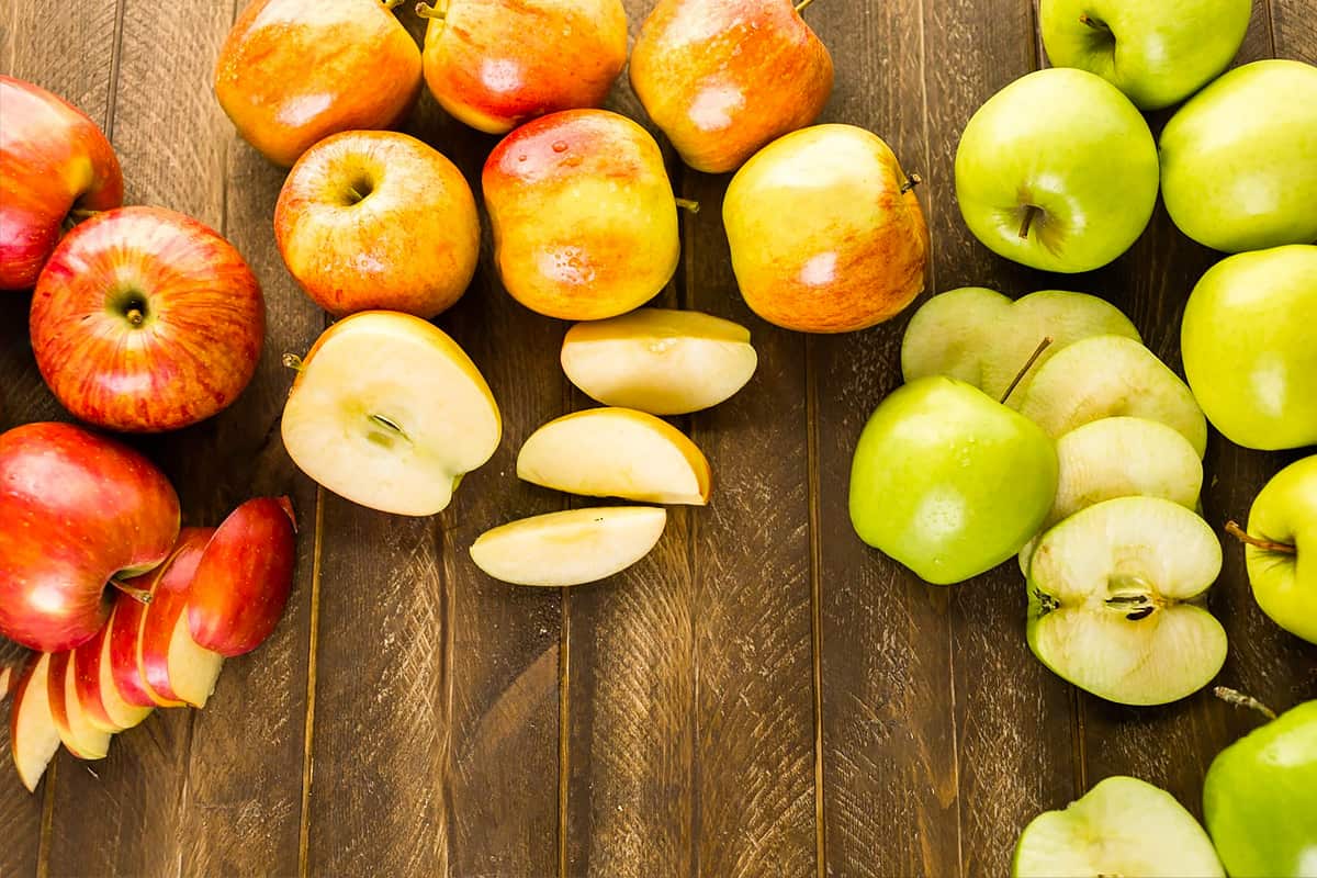 Top view of different types of apple, whole and sliced.