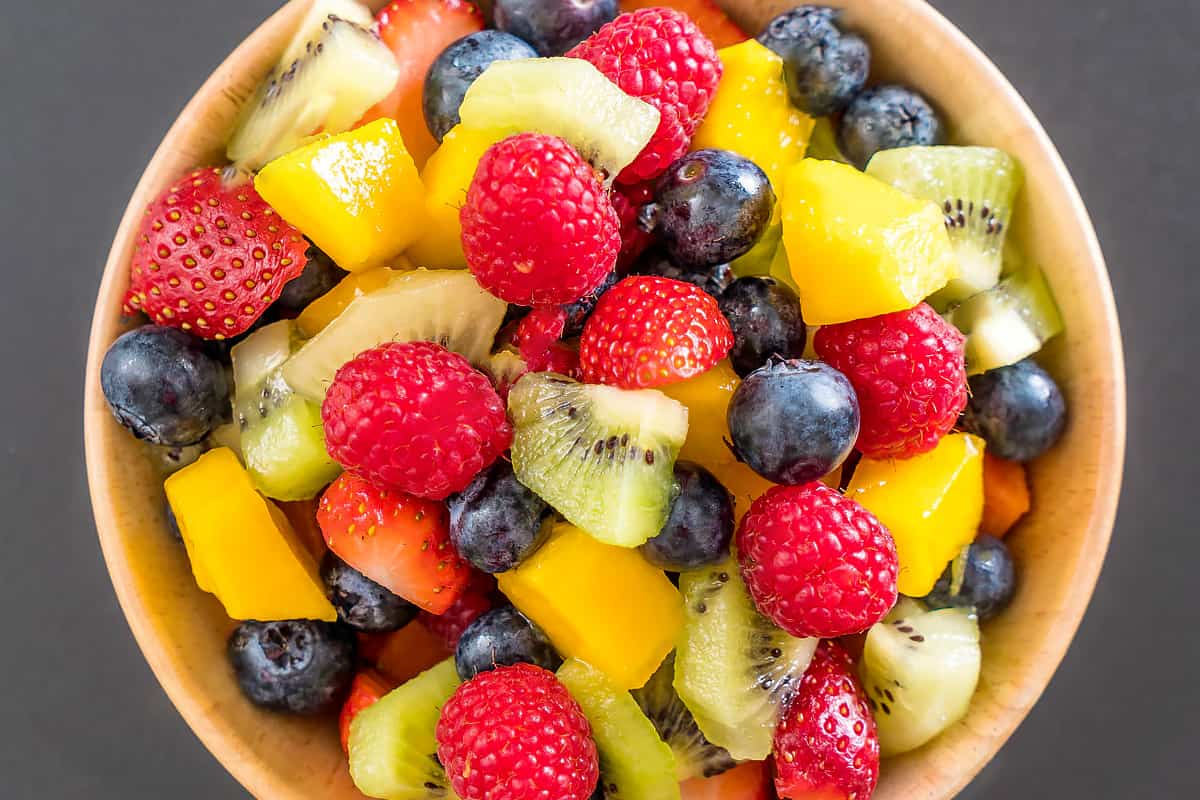 Top view of a bowl with strawberries, blueberries, kiwi, and mango.