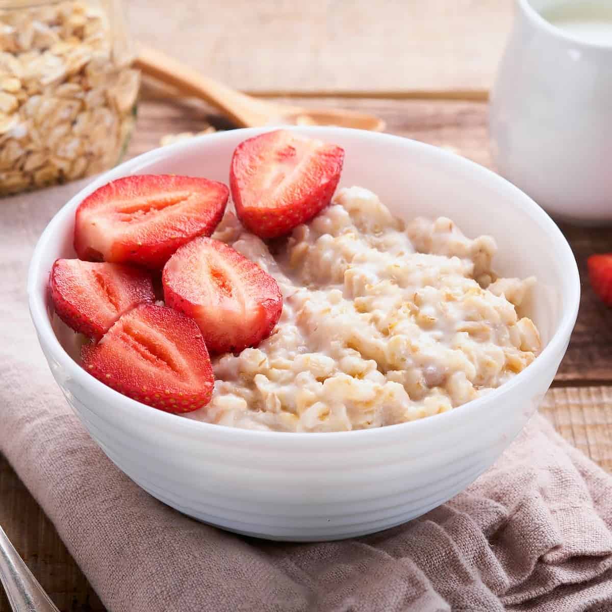 Bowl with oatmeal and strawberries halves.