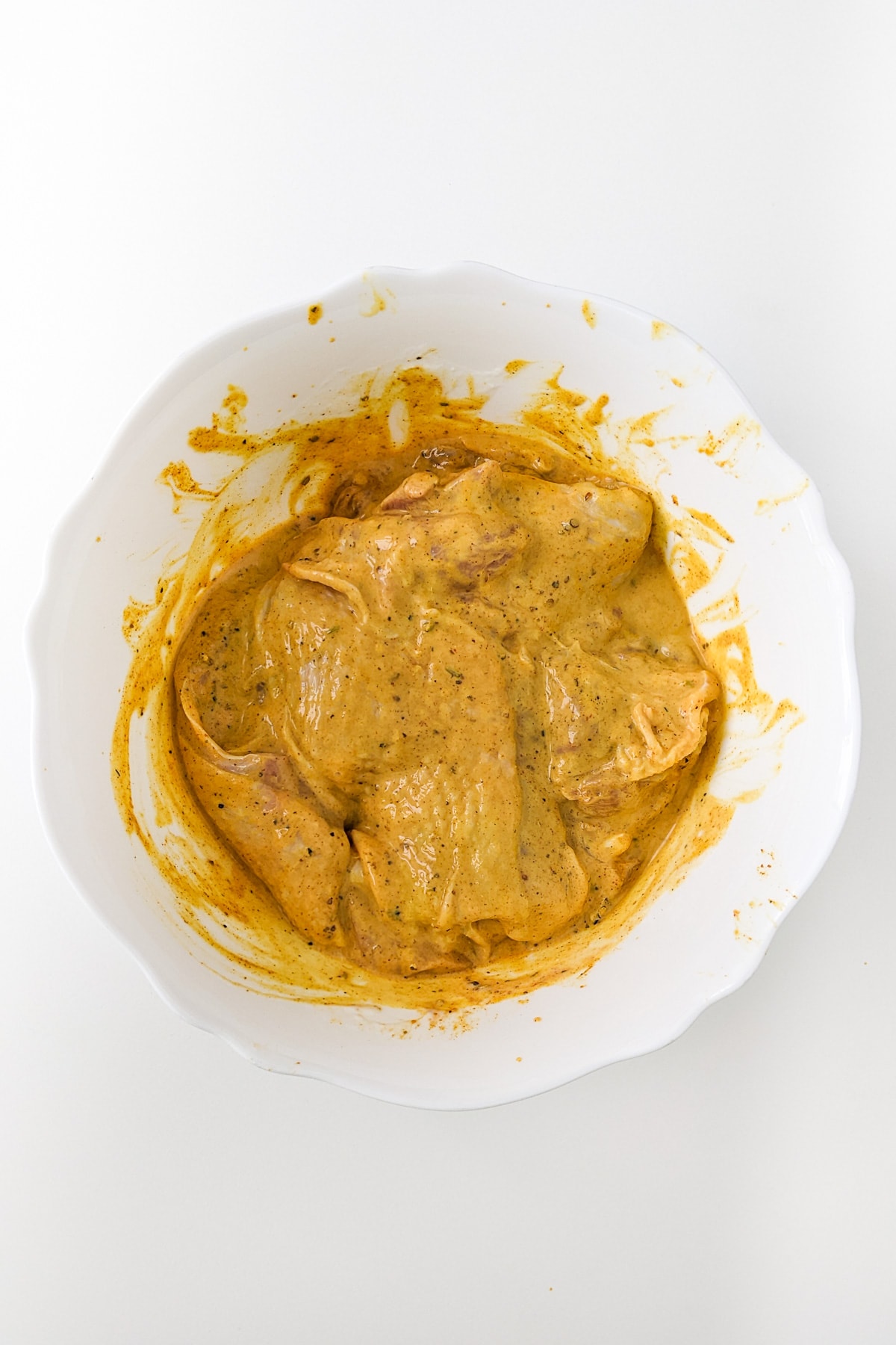 Chicken meat marinating with Arabic spices and yogurt for shawarma.