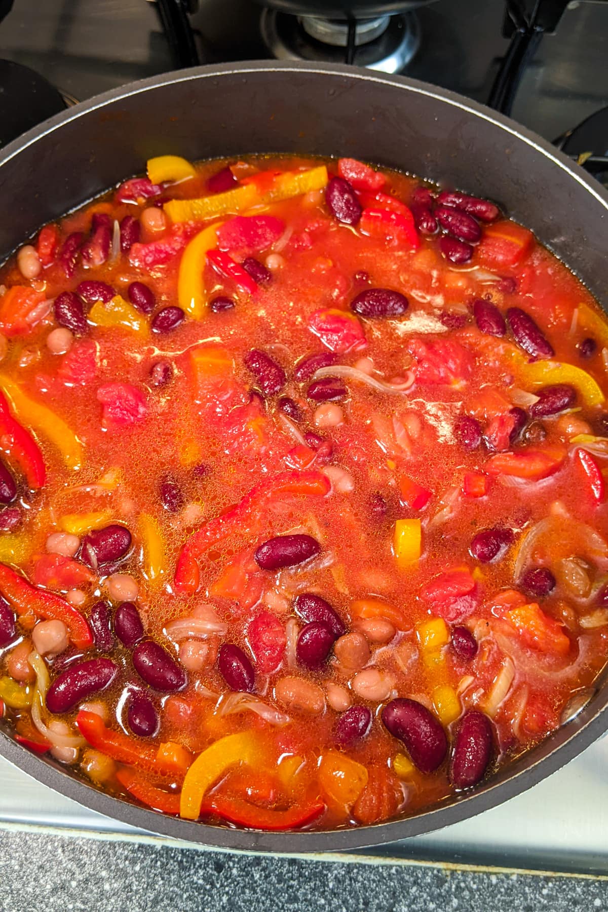 Beans and bell pepper stew on the stove.