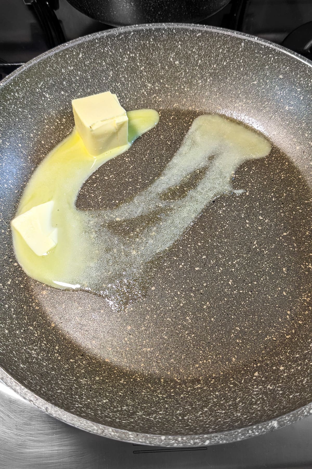 Melting butter in a sauce pan on the stove.
