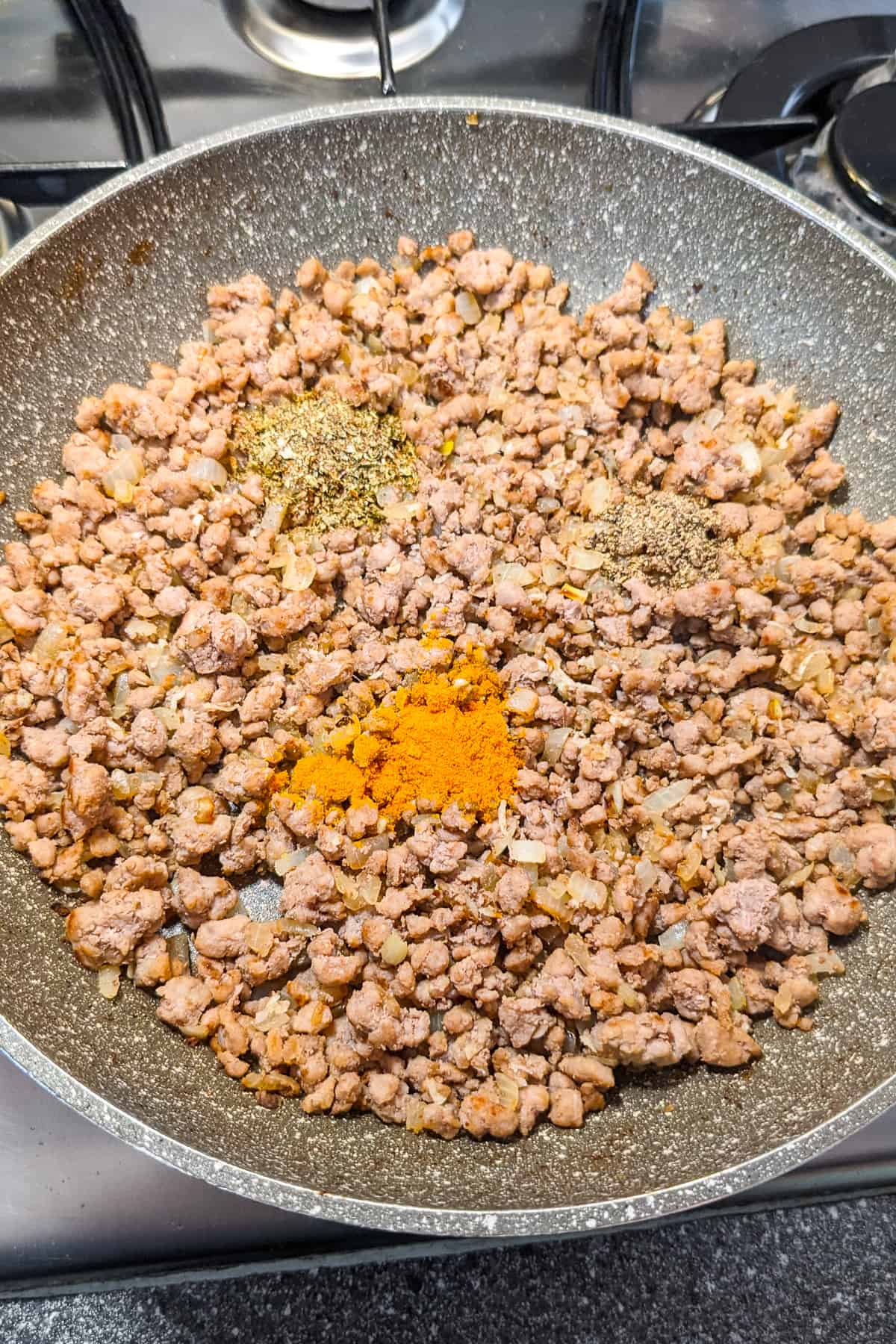Fried minced beef with curcuma, cumin and oregano in a frying pan.