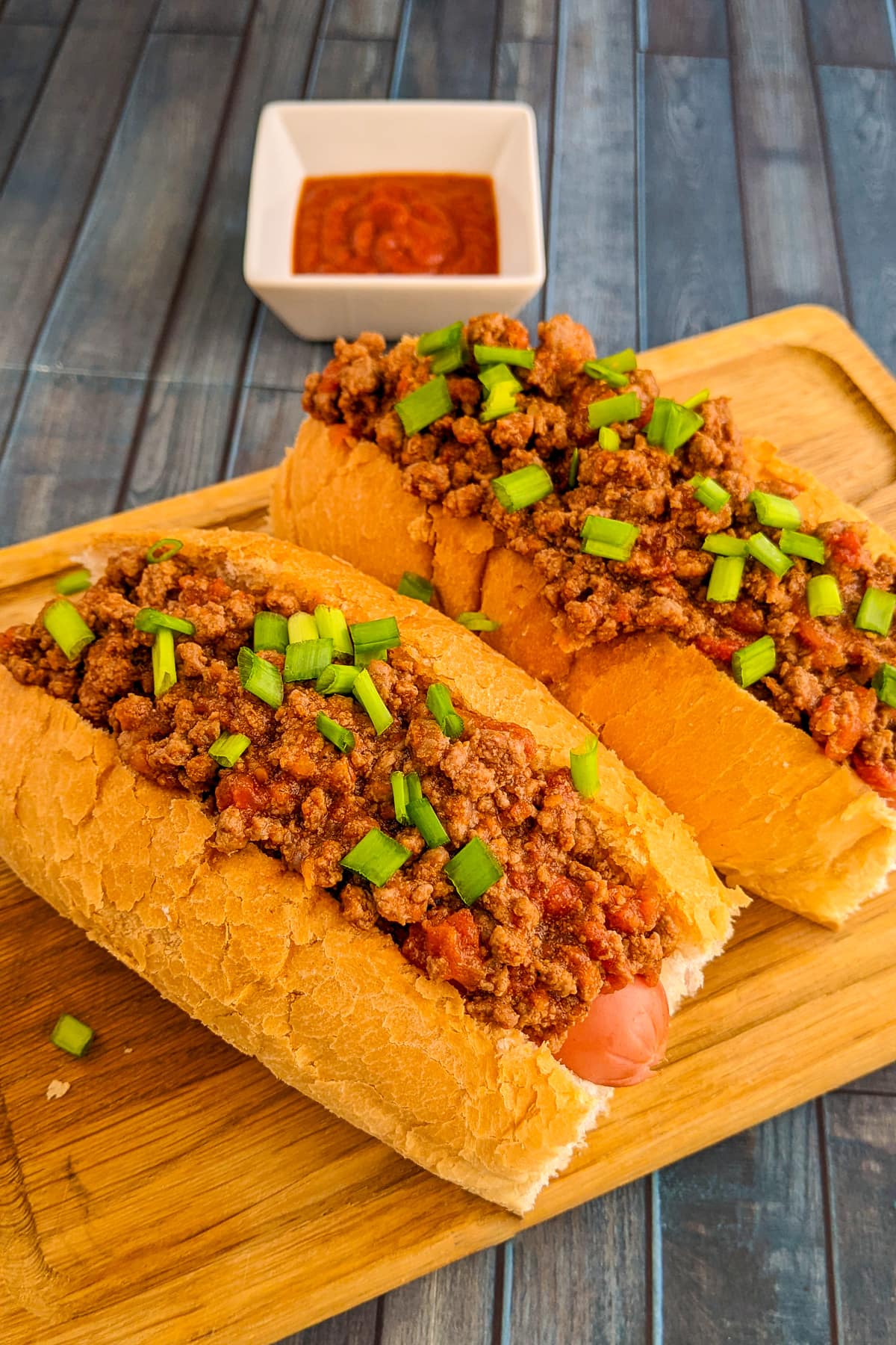 Old-fashioned hot dog with ground beef and sausages in a cutting board.