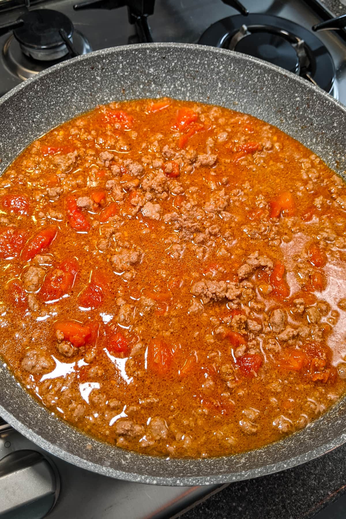 Ground beef sauce in a frying pan on the stove.
