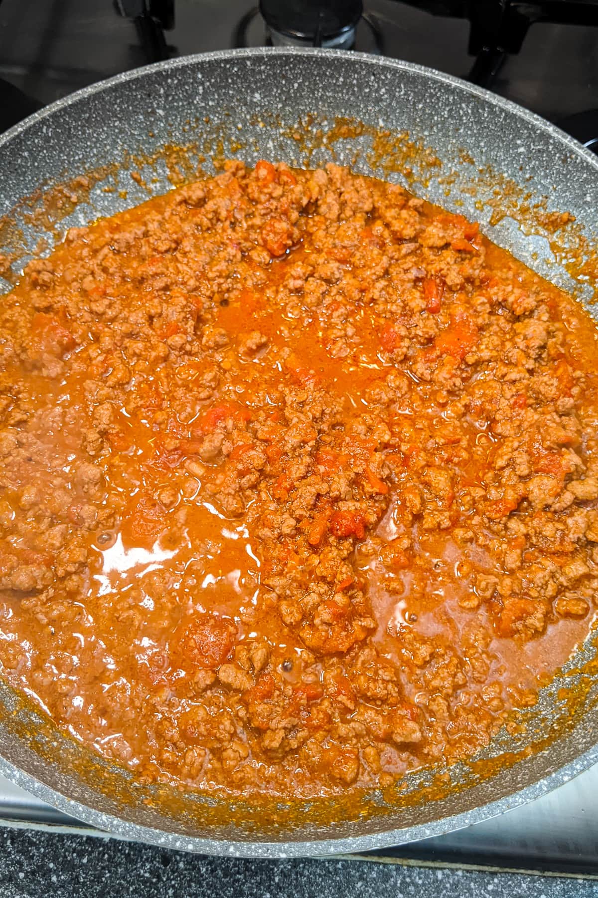 Ground beef sauce in a frying pan on the stove.