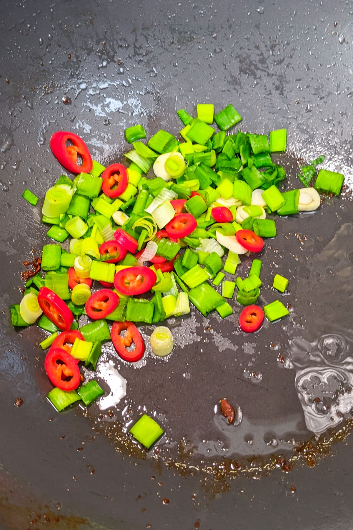 Frying green onions with garlic and chili pepper.