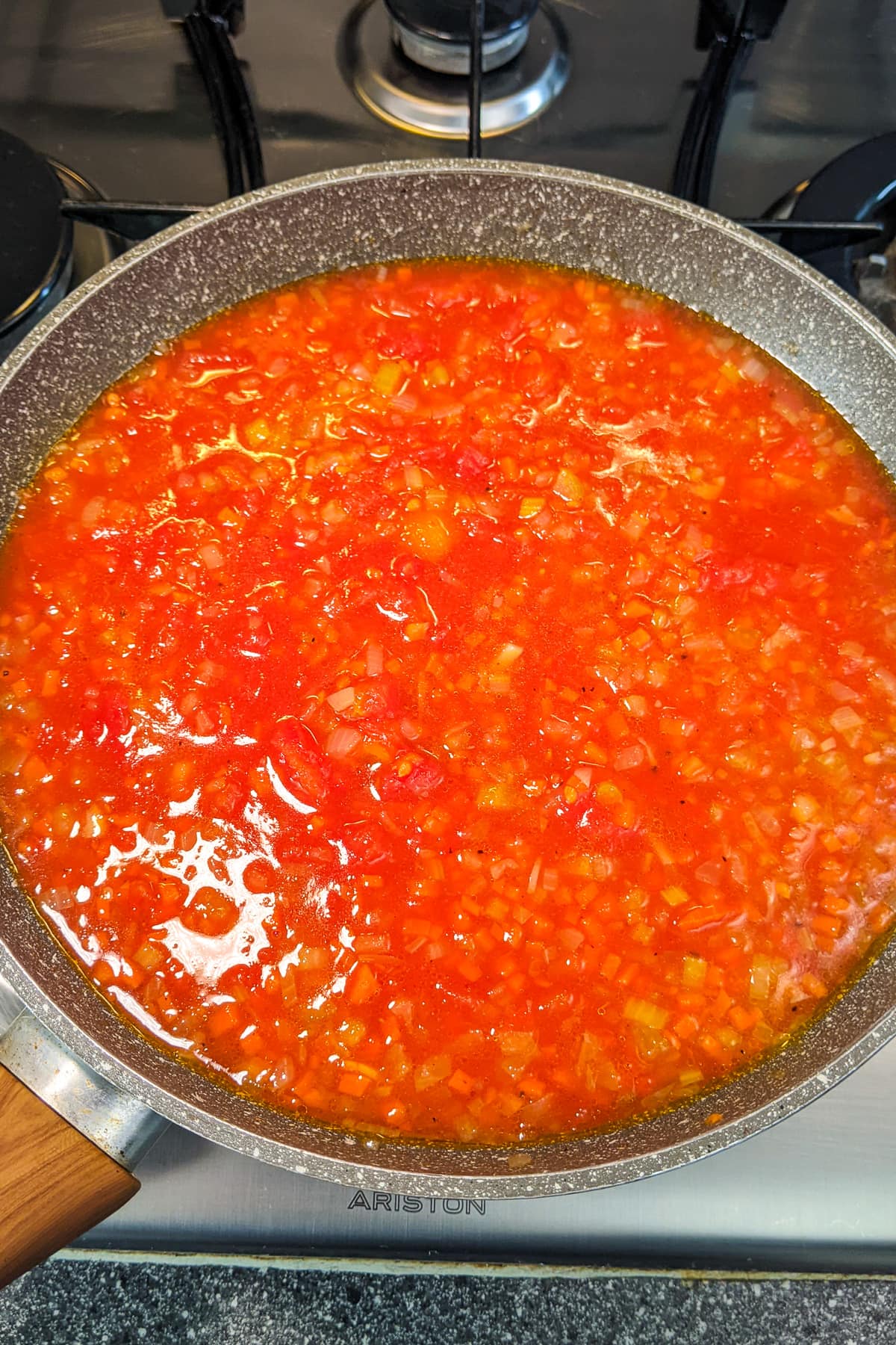 Frying tomato sauce with fried vegetables on the stove.