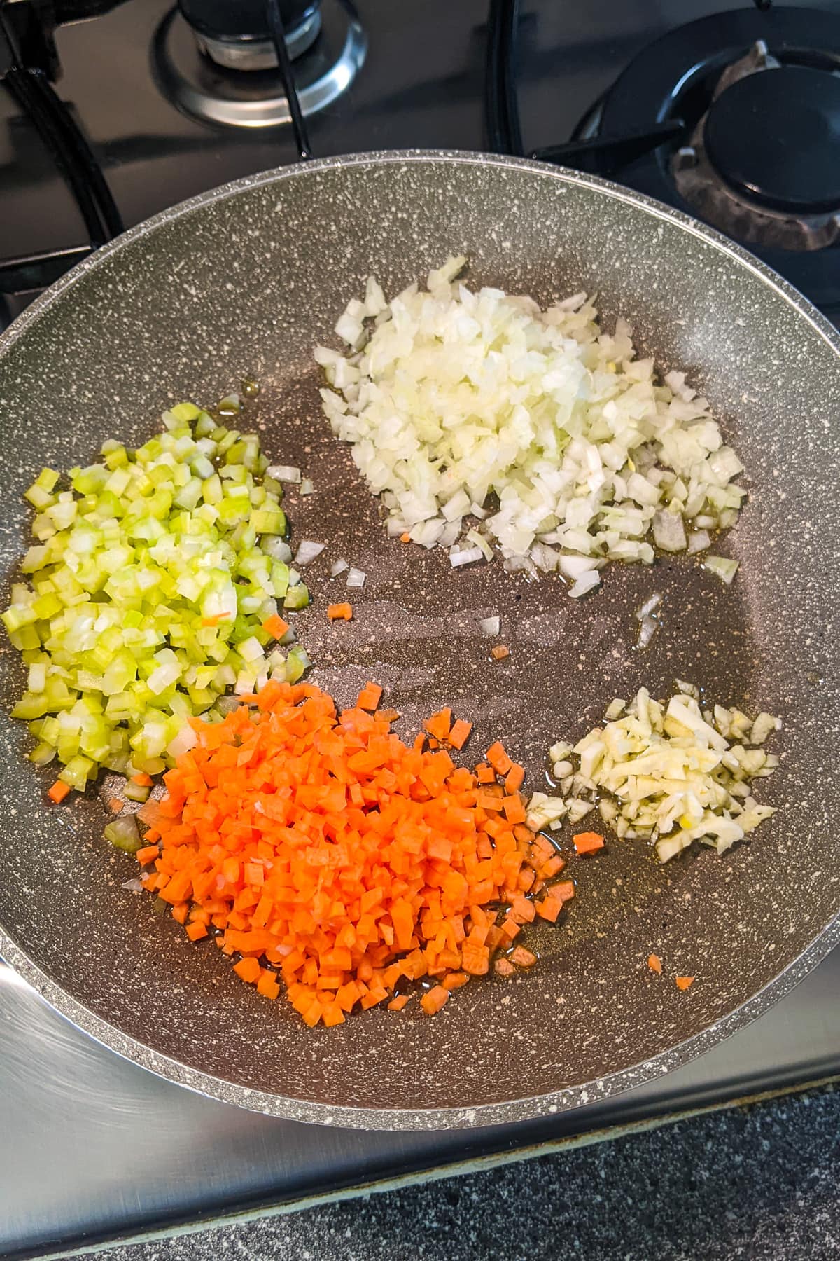 Chopped carrots, onions and leek on a frying pan.