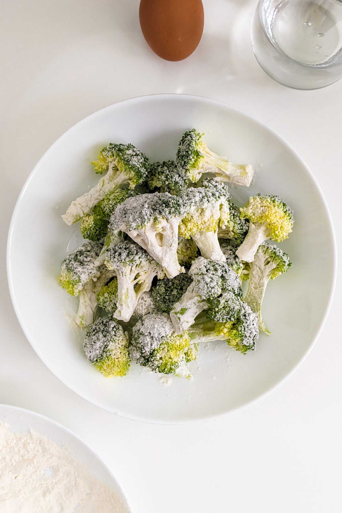 Broccoli florets coated in flour.