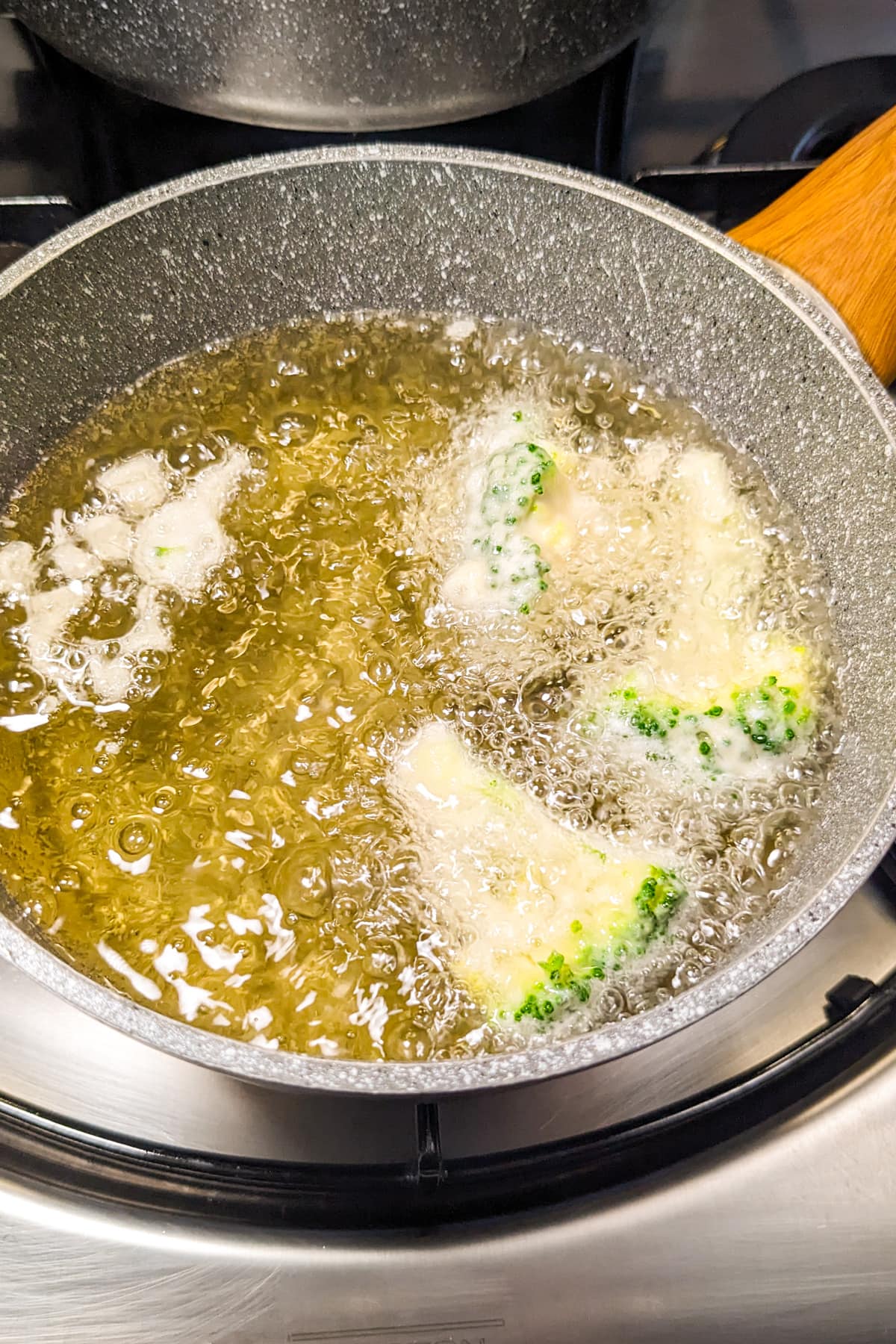 Frying broccoli florets in hot oil.