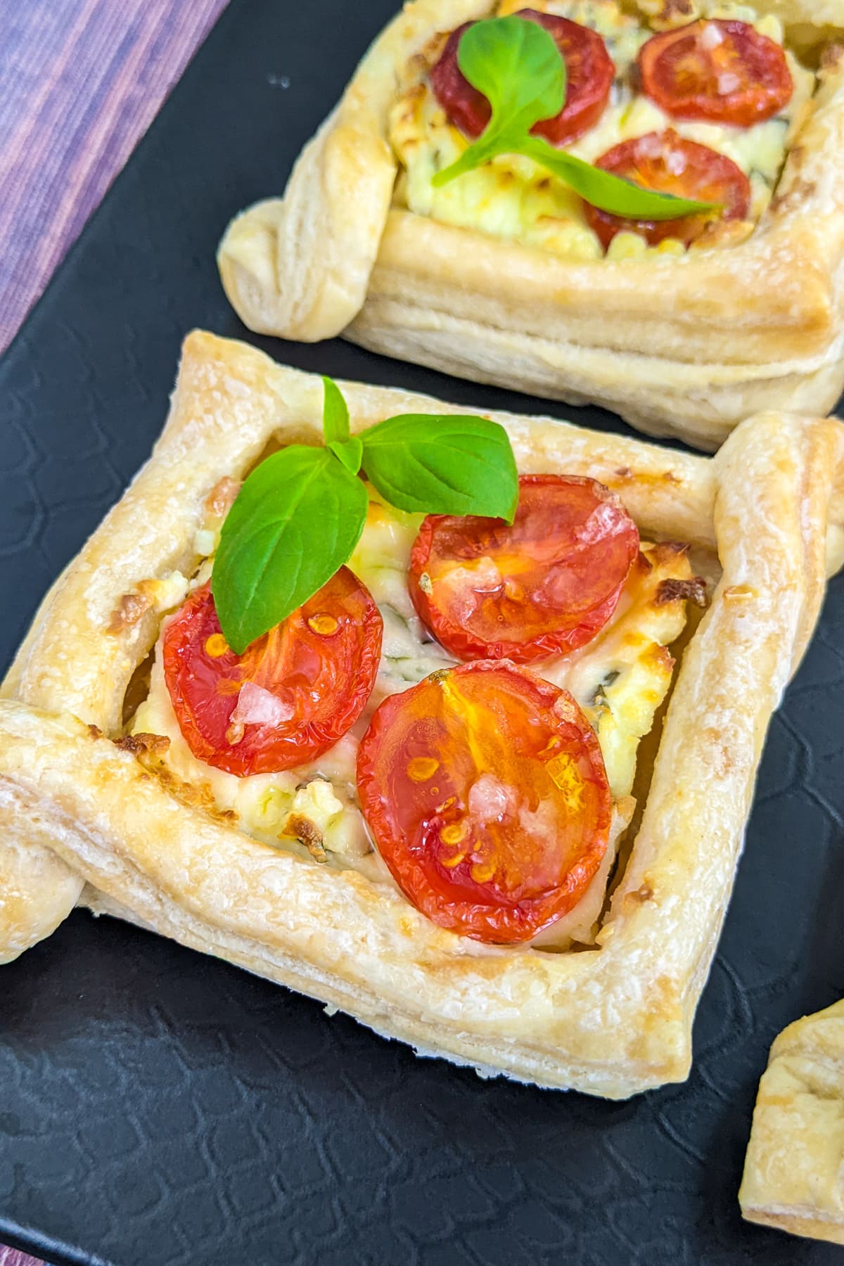 Close look of tomato tartlets with cream cheese and basil leaf,
