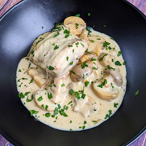 Top view of creamy turkey fricassee sprinkled with chop parsley.