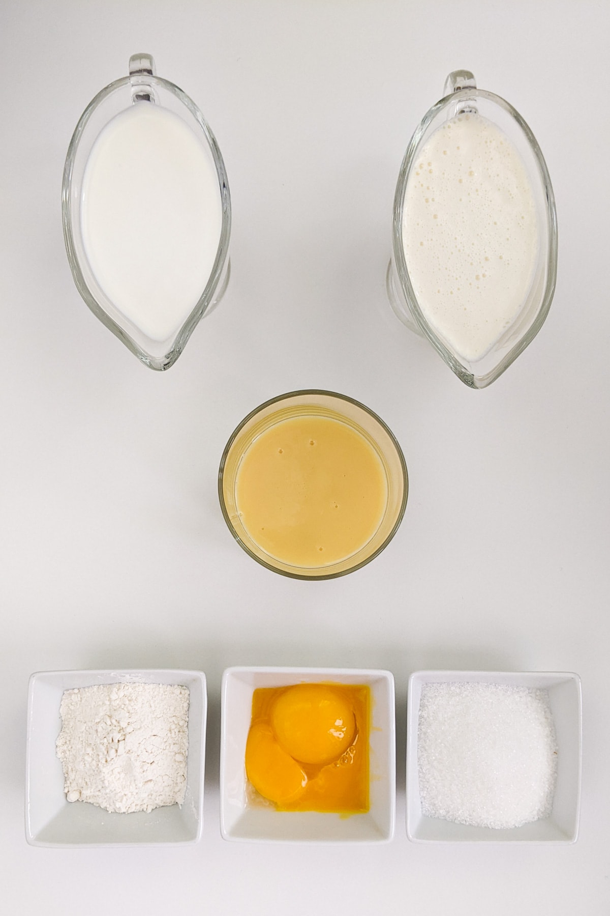 Top view of condensed milk, cream, milk, flour and sugar.