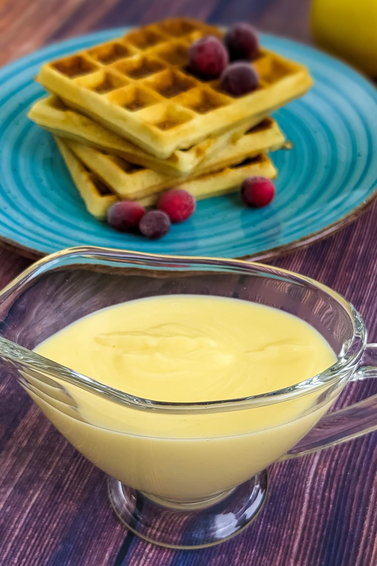 Waffle sauce with condensed milk on a wooden table.