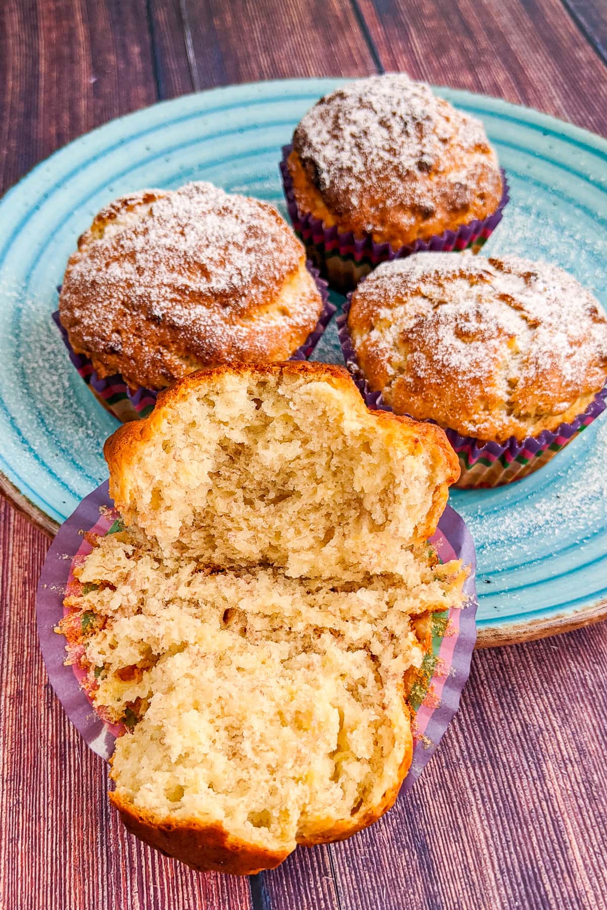 Close look of interior of a fluffy banana muffin on a wooden table.