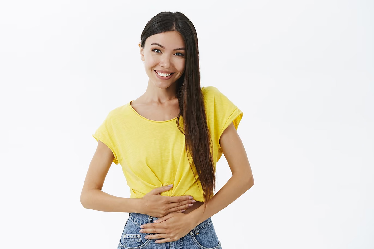 A cheerful girl holding her stomach.